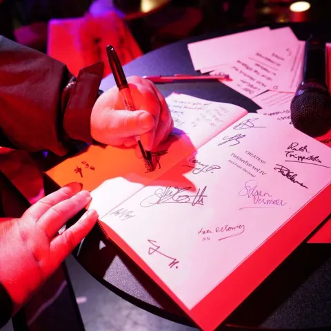 A group of people on stage receive awards, standing in front of a red screen that reads "TWISTED50 VOL 3 WINNERS" under stage lighting.