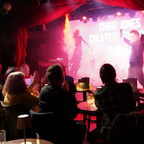 A group of people on stage receive awards, standing in front of a red screen that reads "TWISTED50 VOL 3 WINNERS" under stage lighting.