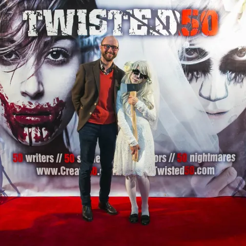 Two people posing for a picture on the red carpet at twisted 50.