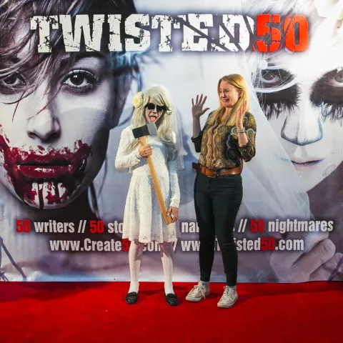 Two people standing on the red carpet at the twisted 50 premiere.