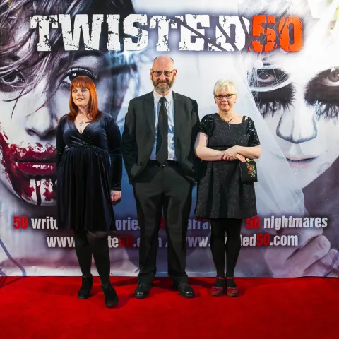 A man and woman posing for a photo at the twisted 50 premiere.