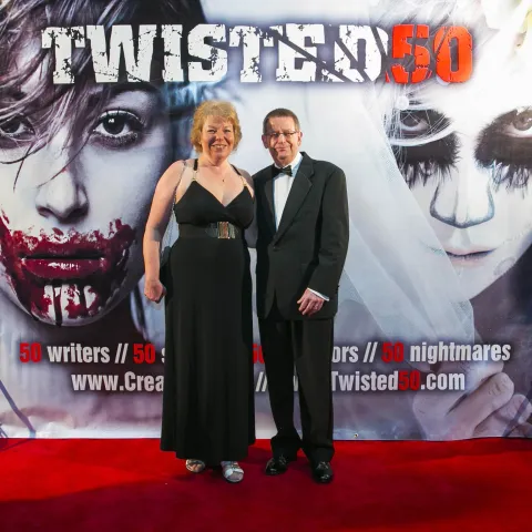 Three women posing for a photo on a red carpet.