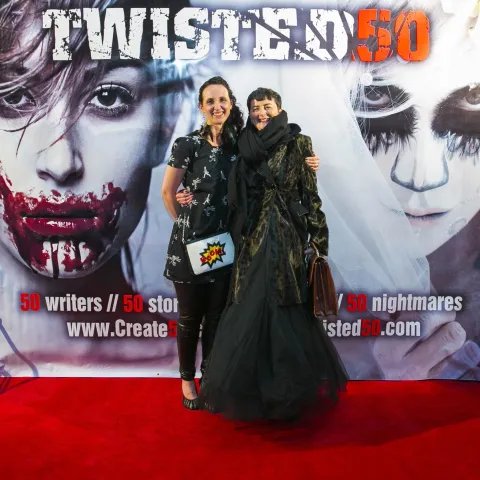 A man and woman posing on the red carpet for twisted 50.