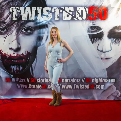 A man and woman posing in front of a poster for twisted 50.