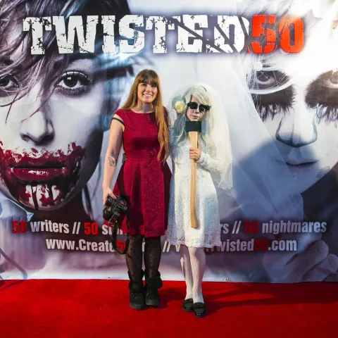 Three women posing for a photo on a red carpet.