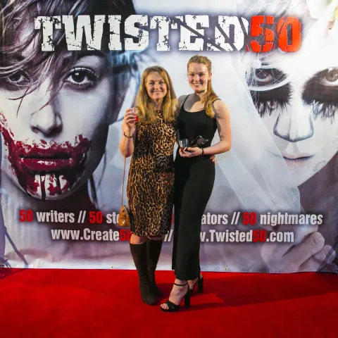 Three women posing for a photo on a red carpet.