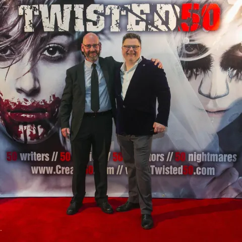 A man and woman posing on the red carpet for twisted 50.