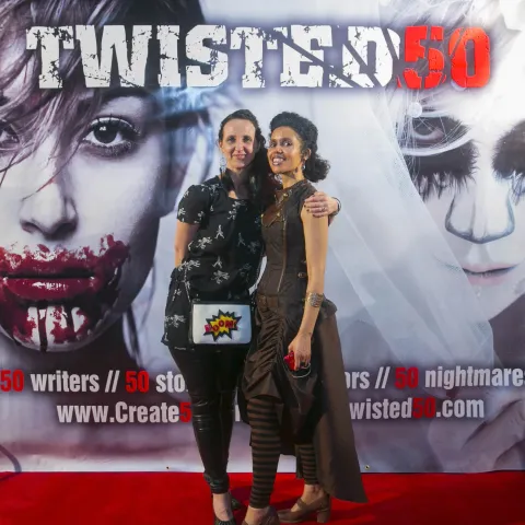 Three women posing for a photo on a red carpet.