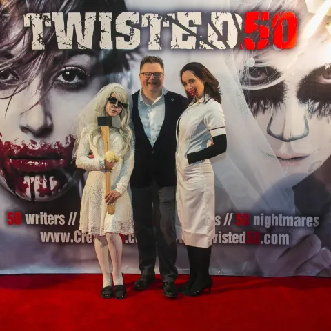 Two people posing for a picture on the red carpet at twisted 50.