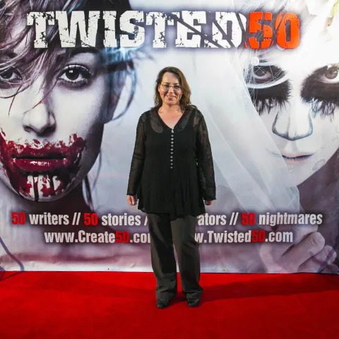 Two people posing for a picture on the red carpet at twisted 50.