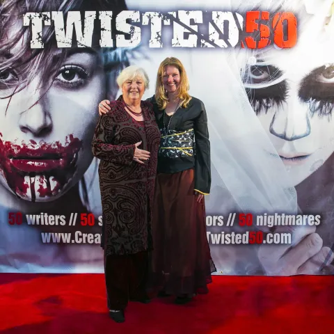 Three women posing for a photo on a red carpet.