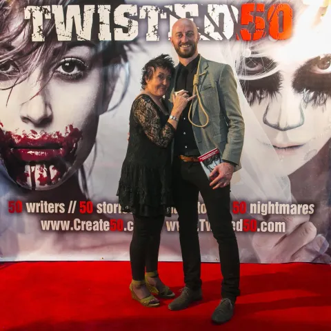 A man and woman posing for a photo at the twisted 50 premiere.