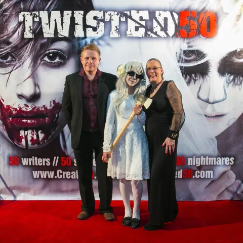 Three women posing for a photo on a red carpet.