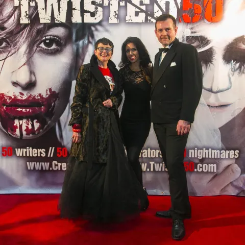 A man and woman posing on the red carpet for twisted 50.