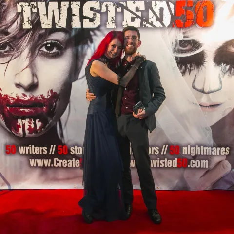 Two people standing on the red carpet at the twisted 50 premiere.
