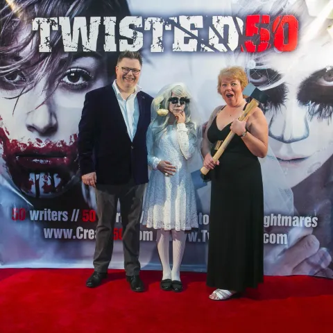 Two people standing on the red carpet at the twisted 50 premiere.