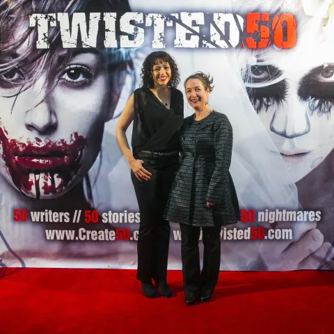 A man and woman posing on the red carpet for twisted 50.