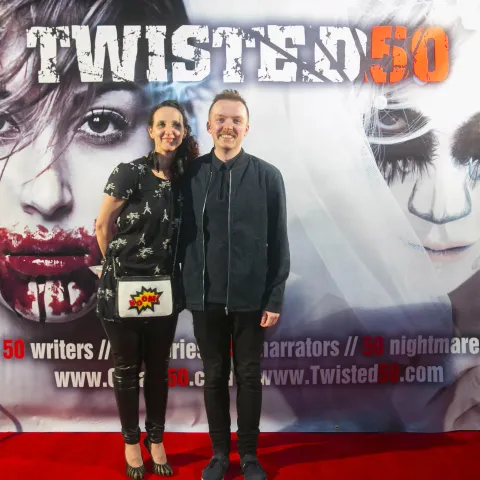 Two people posing for a picture on the red carpet at twisted 50.