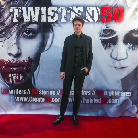 A group of people standing on a red carpet.