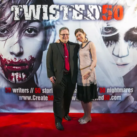 A group of people standing on a red carpet.