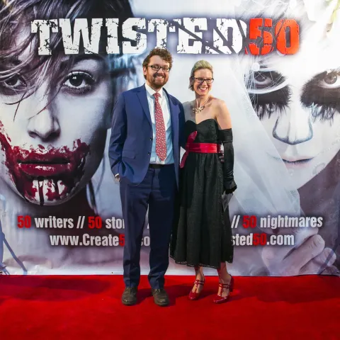 A group of people standing on a red carpet.