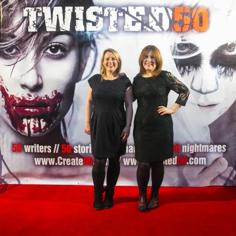 Three women posing for a photo on a red carpet.