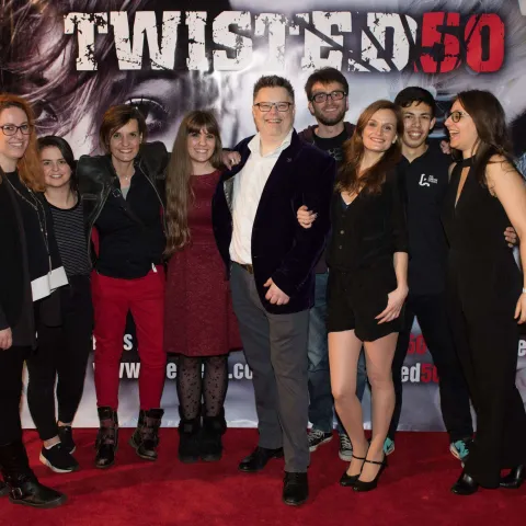 A group of people standing on a red carpet.