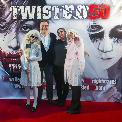 A group of people standing on a red carpet.