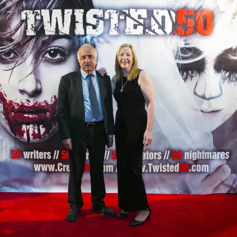 Two people standing on the red carpet at the twisted 50 premiere.