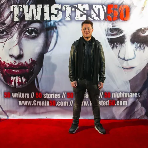 Two people posing for a picture on the red carpet at twisted 50.