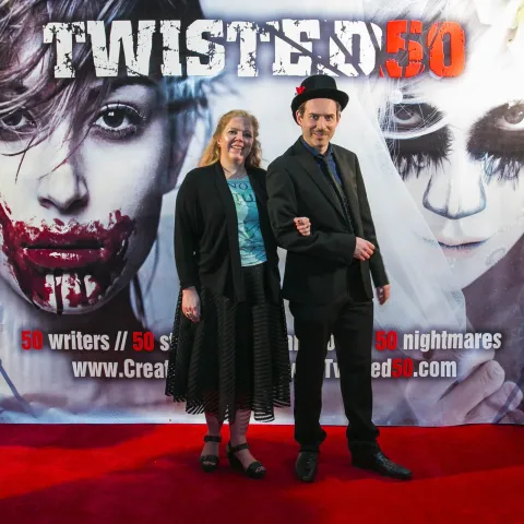 A man and woman posing on the red carpet for twisted 50.