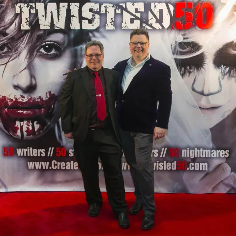 Two people standing on the red carpet at the twisted 50 premiere.