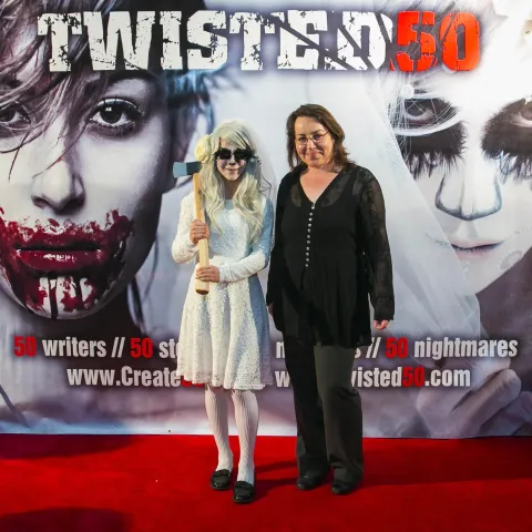 Three women posing for a photo on a red carpet.