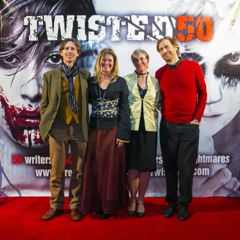Two people posing for a picture on the red carpet at twisted 50.