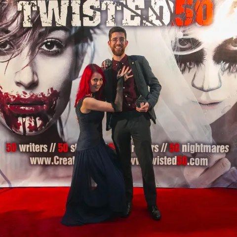 Two people posing for a picture on the red carpet at twisted 50.