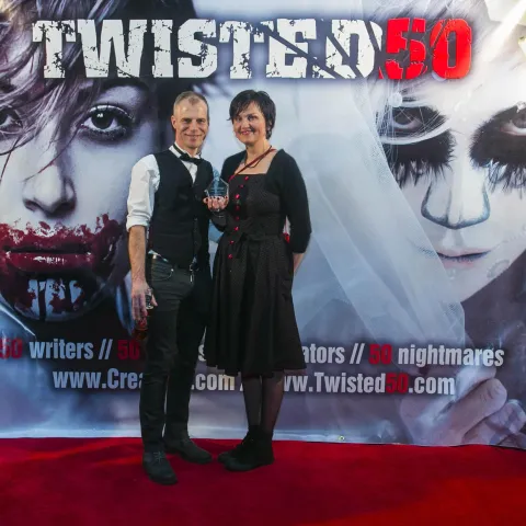 Two people posing for a picture on the red carpet at twisted 50.