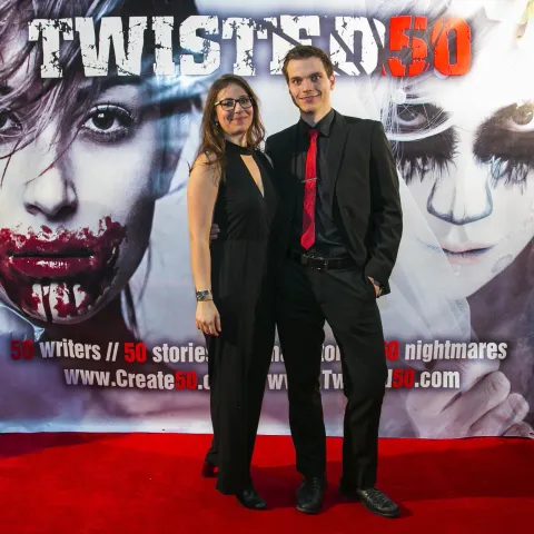 Two people posing for a picture on the red carpet at twisted 50.