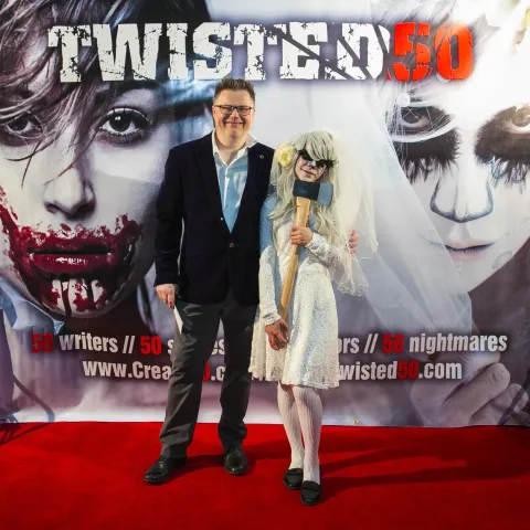 A group of people standing on a red carpet.