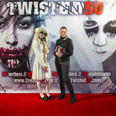 Three women posing for a photo on a red carpet.