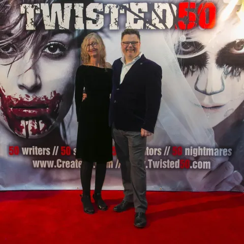 Two people posing for a picture on the red carpet at twisted 50.