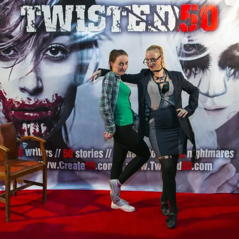 Three women posing for a photo on a red carpet.