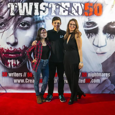 Two people standing on the red carpet at the twisted 50 premiere.