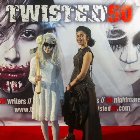 Three women posing for a photo on a red carpet.
